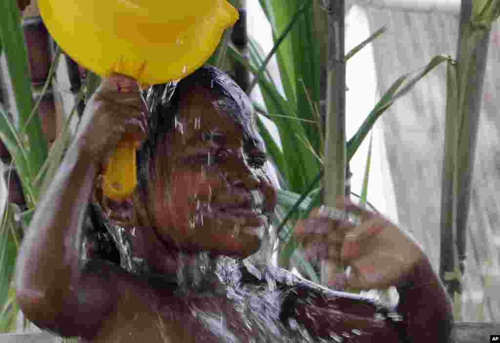 A young girl takes bath outside her home in Prek Kmeng village, Kandal province, eastern Phnom Penh, Cambodia.