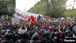 Demonstrators attend a protest to mark the anniversary of a prominent activist's death and against allegations of police abuse, in Tunis, Tunisia, Feb. 6, 2021. 