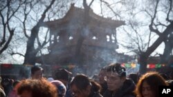 Orang-orang berdoa pada hari pertama Tahun Baru Imlek di Kuil Lama di Beijing, Jumat 16 Februari 2018. Orang Cina di seluruh dunia merayakan datangnya Tahun Anjing pada hari Jumat (16/2) dengan reuni keluarga, petasan dan makanan tradisional.