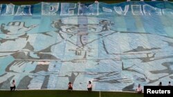 A banner with the Pope's photo is displayed on the field of the Maracana stadium before a soccer game in Rio de Janeiro Jul. 21, 2013.