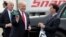 FILE - Wisconsin Gov. Scott Walker, right, presents President Donald Trump with a Milwaukee Buck basketball hat and jersey as he arrives in Kenosha, Wisconsin, April 18, 2017. The ceremonial groundbreaking for a massive $10 billion Foxconn factory complex in Wisconsin was supposed to be evidence that the manufacturing revival fueled by Trump's "America First" policy is well underway. But an announcement this week by Harley-Davidson that it is moving some production of motorcycles overseas to avoid tariffs is fueling unease among voters in Wisconsin, a state Trump barely won and where fellow Republican Gov. Scott Walker is on the ballot.