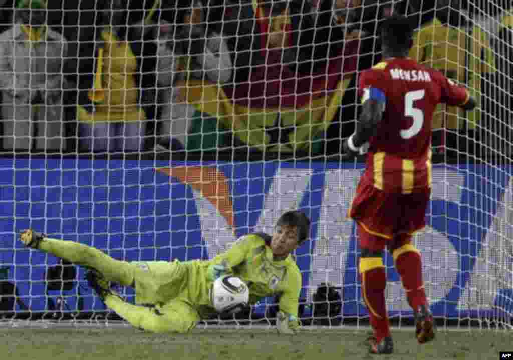 Ghana's John Mensah, right, misses a shootout penalty during the World Cup quarterfinal soccer match between Uruguay and Ghana at Soccer City in Johannesburg, South Africa, Friday, July 2, 2010. (AP Photo/Ivan Sekretarev)