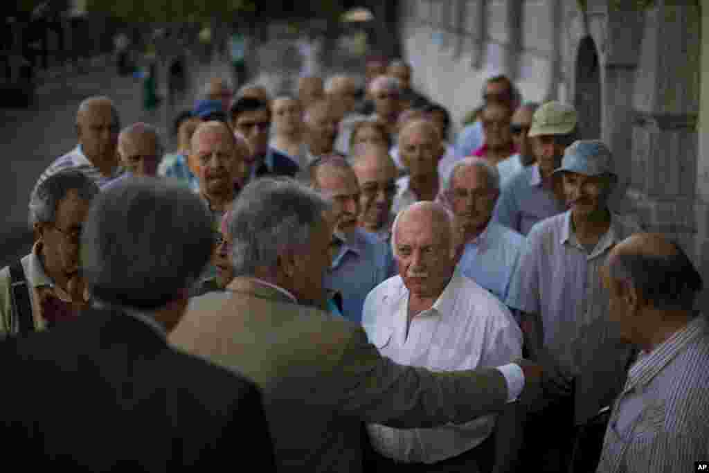 Pensioners wait outside the main gate of the national bank of Greece to withdraw a maximum of 120 euros ($134) in central Athens. Greece&#39;s Prime Minister Alexis Tsipras is seeking backing for a harsh new austerity package from his party to keep his country in the euro.