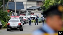 Police officers stand guard at a crossroad near the Tsukui Yamayuri-en, a facility for the handicapped, where a number of people were killed and dozens injured in a knife attack in Sagamihara, outside of Tokyo, Japan, July 26, 2016.