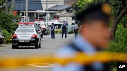 Police officers stand guard at a crossroad near the Tsukui Yamayuri-en, a facility for the handicapped, where a number of people were killed and dozens injured in a knife attack in Sagamihara, outside of Tokyo, Japan, July 26, 2016.