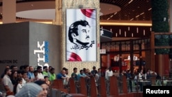A painting depicting Qatar’s Sheikh Tamim bin Hamad Al Thani is seen as people gather at the Mall of Qatar in Doha, July 5, 2017. 