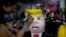 FILE - Alicia Lopez Fernandez paints a pinata depicting Donald Trump at her family's store "Pinatas Mena Banbolinos" in Mexico City, July 10, 2015. In a surprise move, Donald Trump will travel to Mexico Aug. 31 to meet with President Enrique Pena Nieto.