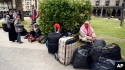 A group of Syrian refugees gather with their belongings in Independence Square in Montevideo, Uruguay, Sept. 7, 2015. 