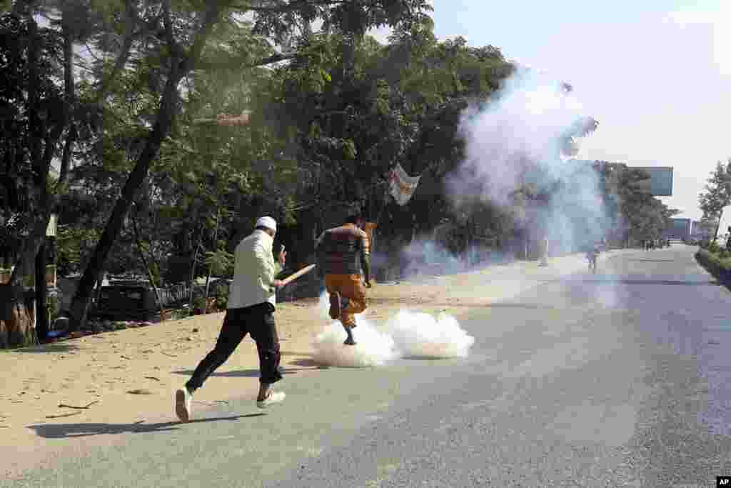 Activists from Bangladesh’s main opposition Bangladesh Nationalist Party run for cover from tear gas shells and rubber bullets fired during a strike in Dhaka, Nov. 26, 2013.