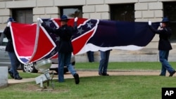 A Mississippi Highway Safety Patrol honor guard carefully folds the retired Mississippi state flag after it was raised over the Capitol grounds one final time in Jackson, Miss., July 1, 2020.