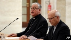 Los prelados Luis Fernando Ramos Perez, derecha, y Juan Ignacio Gonzalez, miembros de la Conferencia de Obispos de Chile hablan con periodistas en El Vaticano, el viernes 18 de mayo, de 2018.