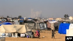 Smoke from Israeli bombardment billows in Rafah in the background as seen from a camp for displaced people in Khan Yunis on June 21, 2024, in the southern Gaza Strip, amid the ongoing conflict in the Palestinian territory between Israel and Hamas.