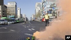 A South Korean government official controls traffic as part of a civil defense drill in Seoul, 15 Dec 2010