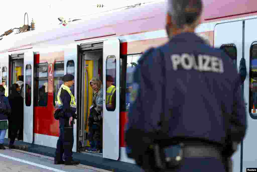 Migrants enter a regional train at the main railway station in Munich.