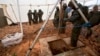 Israeli soldiers stand around the opening of a hole that leads to a tunnel that the army says crosses from Lebanon to Israel, near Metula, Dec. 19, 2018.