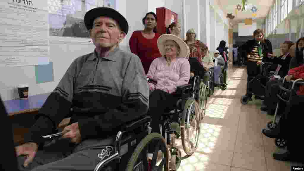 Sur des fauteuils roulant, des&nbsp; Israéliens attendent de voter à un bureau de vote à Holon, près de Tel Aviv, le 17 mars 2015.