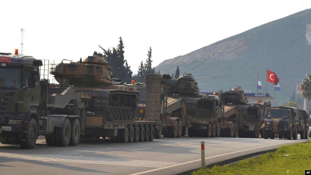 FILE - Turkish military trucks carrying tanks and personnel carriers are destined for the border with Syria, Jan. 14, 2019. 