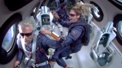Richard Branson et les membres d'équipage flottant en apesanteur à bord de l'avion-fusée de passagers VSS Unity de Virgin Galactic.