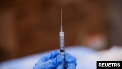 FILE - A syringe is filled with a dose of Pfizer's coronavirus disease (COVID-19) vaccine at a pop-up community vaccination center at the Gateway World Christian Center in Valley Stream, Feb. 23, 2021. 