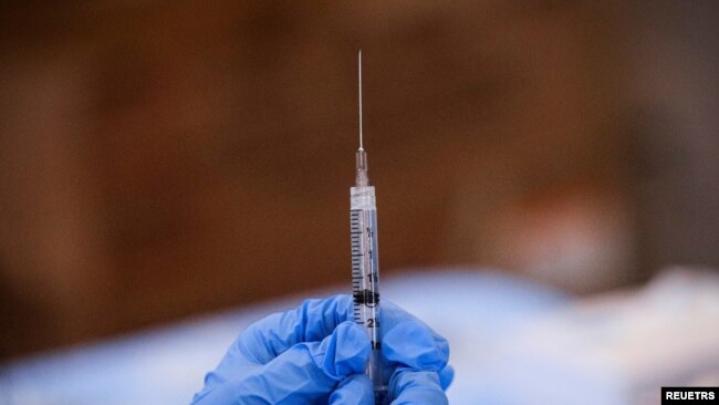 FILE - A syringe is filled with a dose of Pfizer's coronavirus disease (COVID-19) vaccine at a pop-up community vaccination center at the Gateway World Christian Center in Valley Stream, Feb. 23, 2021.