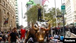 Aktivis perubahan iklim dari organisasi yang menamakan diri mereka "Extinction Rebellion" melakukan aksi protes di Wall Street Bull di Lower Manhattan, New York, 7 Oktober 2019. 