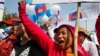 Cambodian garment workers shout slogans during a gathering to mark May Day celebrations in Phnom Penh, Cambodia, Friday, May 1, 2015. Garment workers staged a rally to demand higher wage and better working condition. The placard at right in the background reads: "Demanding the government urgently set up the labor court." (AP Photo/Heng Sinith)