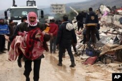 叙利亚靠近土耳其的边界地区遭地震袭击，一名男子抱着一个死难者。（2023年2月6日）