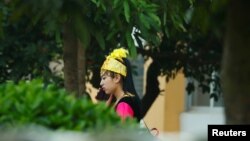 A woman in Uyghur ethnic dress stands inside the compound of Universal Electronics Inc. in Qinzhou, Guangxi Autonomous Region, China, April 13, 2021.