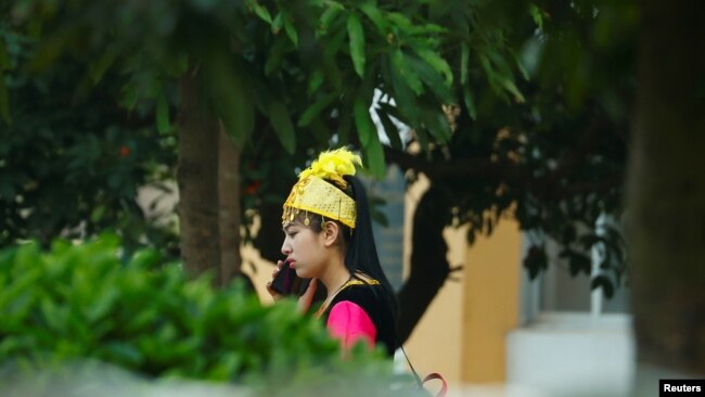 A woman in Uyghur ethnic dress stands inside the compound of Universal Electronics Inc. in Qinzhou, Guangxi Autonomous Region, China, April 13, 2021.