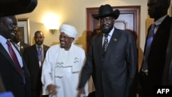 Sudanese President Omar al-Bashir (Center L) smiles after shaking hands with his South Sudanese counterpart Salva Kiir (Center R) following a meeting in the Ethiopian capital Addis Ababa, July 14, 2012. 
