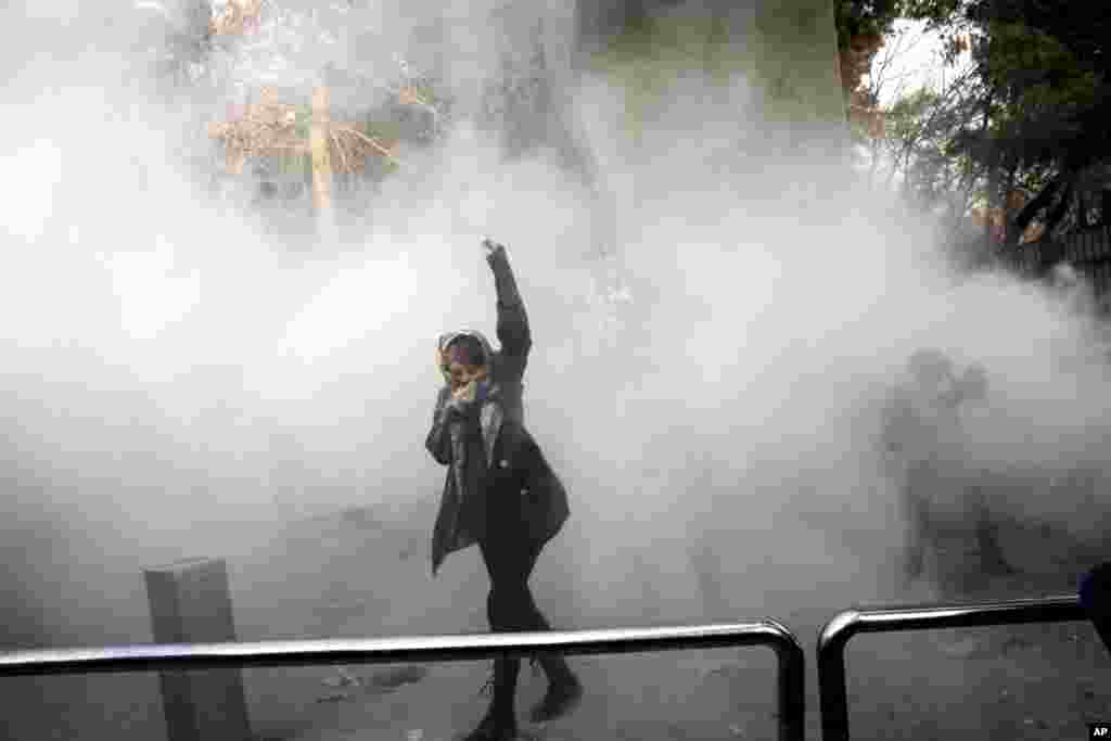 شلیک گاز اشک آور توسط پلیس ضدشورش برای مقابل با دانشجویان معترض در دانشگاه تهران. عکس این زن جوان معترض در خیلی از خبرگزاری های خارجی بازتاب داشته است.