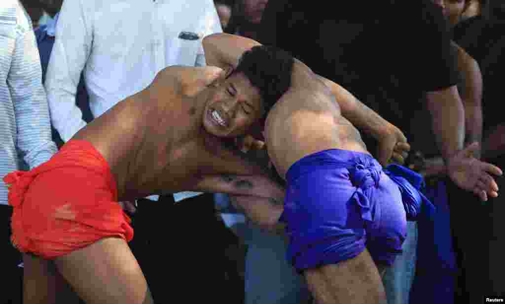 Men wrestle during an annual buffalo-racing ceremony at Virhear Sour village in Kandal province, Cambodia. The ceremony, which started more than 70 years ago, is held to honor the Neakta Preah Srok pagoda spirit.