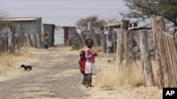 Children walk smong miner's shacks near Rustenburg, South Africa, Aug. 28, 2012.