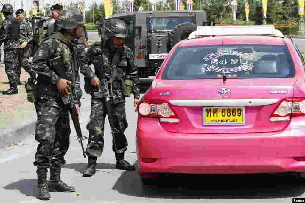 Tentara Thailand memeriksa sebuah taksi di dekat kemah dimana para pendukung Pemerintah Thailand &nbsp;yang dikenal dengan barisan &quot;Kaos Merah&quot; berkumpul di pinggiran kota Bangkok, 20 Mei 2014.