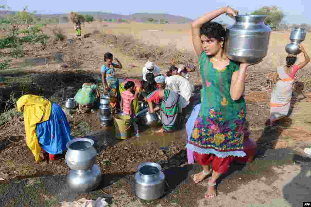 인도 남부 텔랑가나 주 찬담펫만달의 수도관이 파열된 가운데, 람바디 부족 마을 주민들이 새어 나오는 물을 받고 있다.
