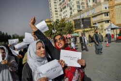 Perempuan Afghanistan meneriakkan slogan-slogan dan memegang plakat selama protes hak-hak perempuan di Kabul, 21 Oktober 2021.