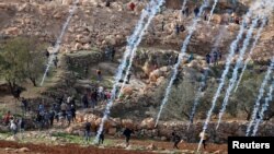 Tear gas canisters are fired by Israeli troops towards Palestinians during a protest against Israeli land seizures for Jewish settlements, near Ramallah in the occupied West Bank, Nov. 30, 2018.