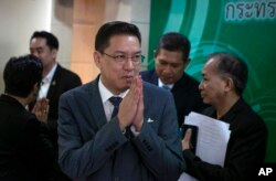 FILE - Thai Minister of Digital Economy and Society, Phutthipong Punnakan, center, greets during a news conference to announce the launching of government run anti-fake news center in Bangkok, Thailand Wednesday, Aug. 21. 2019.