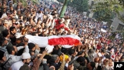 Egyptians carry the body of a protester killed during recent clashes in Tahrir Square, Cairo, December 19, 2011