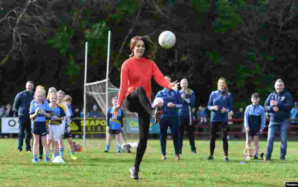 Britain&#39;s Catherine, Duchess of Cambridge reacts as she plays Gaelic football during a visit to the local Salthill Knocknacarra Gaelic Athletic Association Club (GAA) in Galway, Ireland.