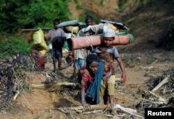 Rohingya refugees walk on a muddy path after crossing the Bangladesh-Myanmar border in Cox's Bazar, Bangladesh, Sept. 8, 2017.