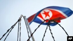 A North Korean flag is seen behind razor wire on top of a wall at the North Korean embassy in Kuala Lumpur, Malaysia, March 9, 2017