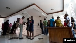 Gay and human rights activists wait outside the courts before filing a constitutional petition against a new anti-homosexuality law, in Uganda's capital Kampala, March 11, 2014.