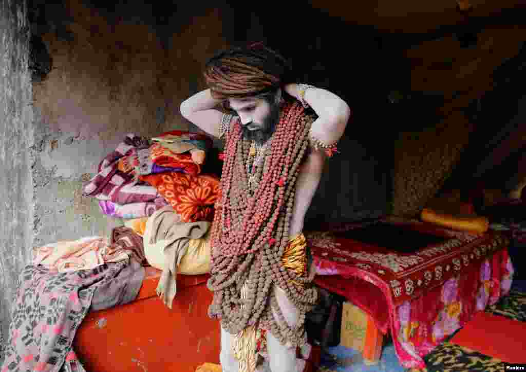 A Naga Sadhu or Hindu holy man adjusts the beads around his neck ahead of the first Shahi Snan at "Kumbh Mela" or the Pitcher Festival in Haridwar, India.