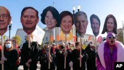 Abortion rights advocates holding cardboard cutouts of the Supreme Court justices demonstrate in front of the U.S. Supreme Court, Dec. 1, 2021, in Washington.