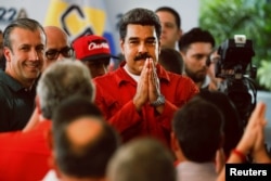 FILE - President Nicolas Maduro gestures as he registers his candidacy for re-election at the National Electoral Council (CNE) headquarters in Caracas, Feb. 27, 2018.