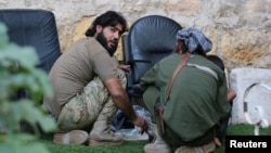 Rebel fighters of al-Jabha al-Shamiya (Levant Front) have their meal in the rebel-held al-Sheikh Said neighborhood of Aleppo, Syria, Sept.1, 2016.