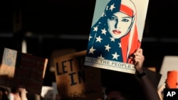 A protester holds a sign at San Francisco International Airport during a demonstration to denounce President Donald Trump's executive order that bars citizens of seven predominantly Muslim-majority countries from entering the U.S., Jan. 28, 2017.
