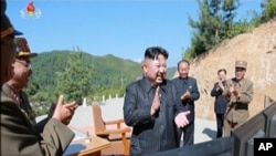 FILE - This image made from video of a news bulletin aired by North Korea's KRT July 4, 2017, shows what was said to be North Korea leader Kim Jung Un, center, applauding after the launch of a Hwasong-14 intercontinental ballistic missile.