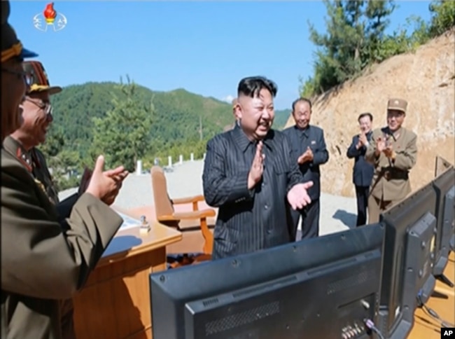 FILE - This image made from video of a news bulletin aired by North Korea's KRT July 4, 2017, shows what was said to be North Korea leader Kim Jung Un, center, applauding after the launch of a Hwasong-14 intercontinental ballistic missile, ICBM.